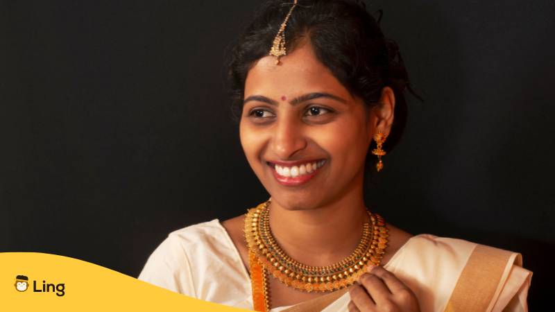 Junge Frau in traditionellem Saree und Schmuck aus Kerala. Lerne die Malayalam Aussprache mit der Ling-App.